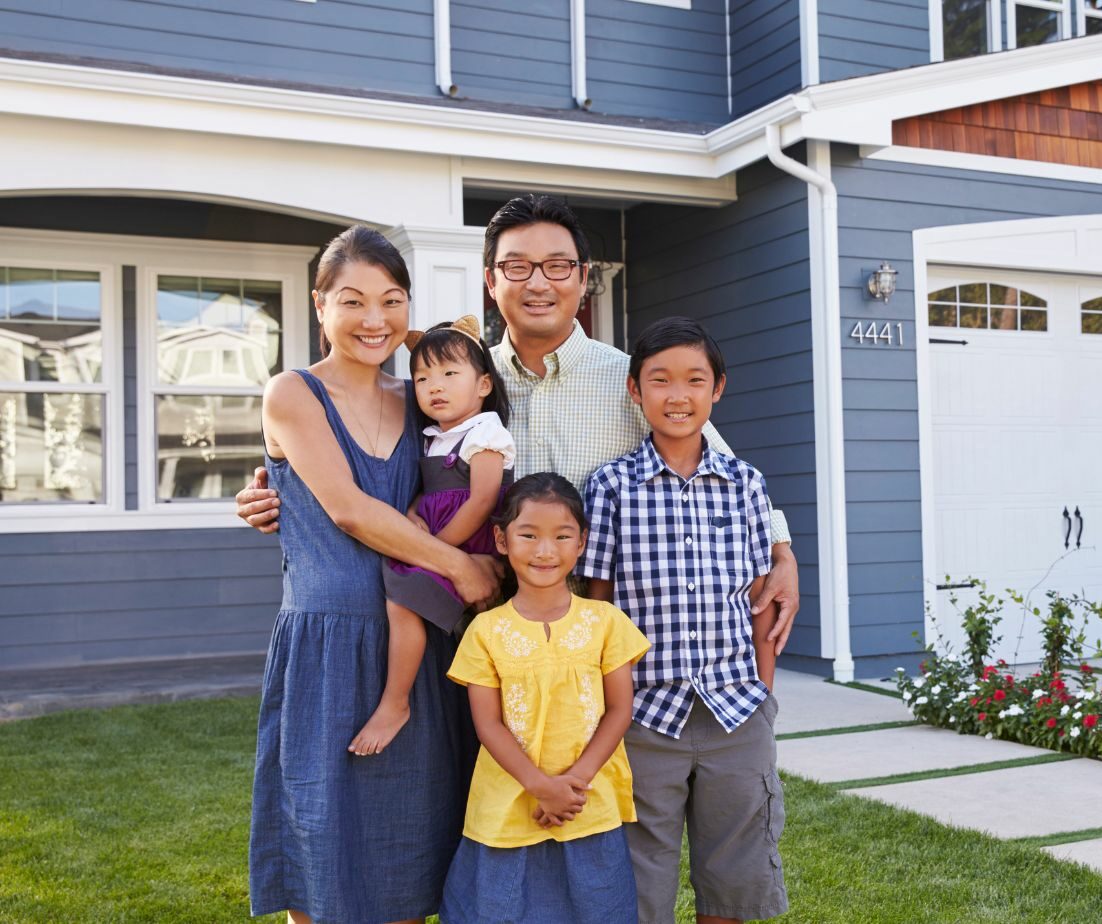 A happy family standing outside their beautiful home, showcasing a well-maintained roof and exterior. Empire Contractors LLC provides expert roofing, window, and gutter services in Cincinnati, OH, and surrounding areas to keep homes safe and looking their best.