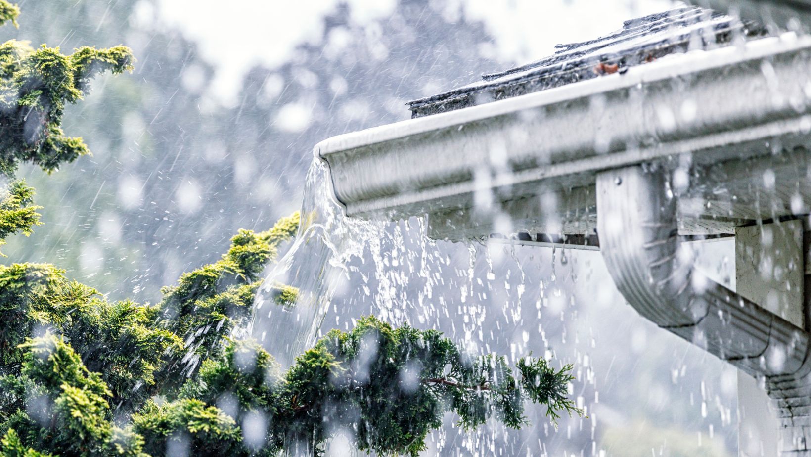 A residential gutter during a heavy storm, with rainwater flowing through, highlighting the importance of proper drainage. Empire Contractors LLC provides expert gutter installation, cleaning, and maintenance services in Cincinnati, OH, and surrounding areas to protect homes from water damage.